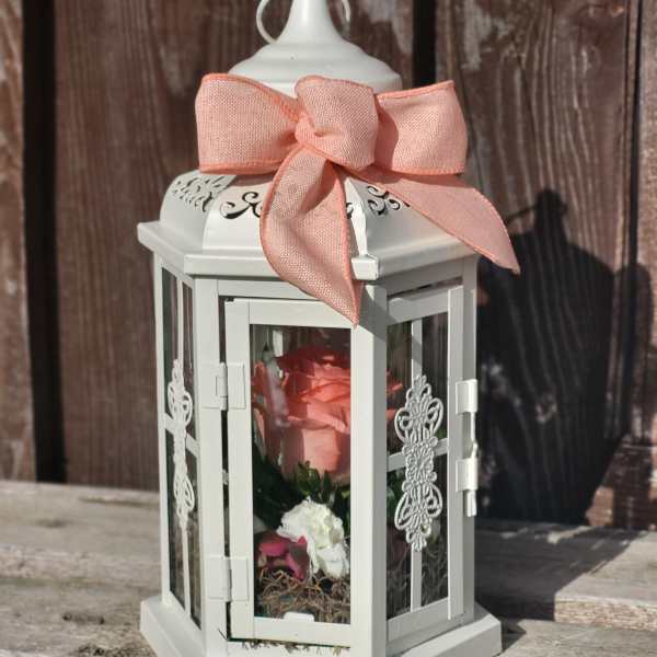 White lantern with a pink ribbon and a pink rose inside