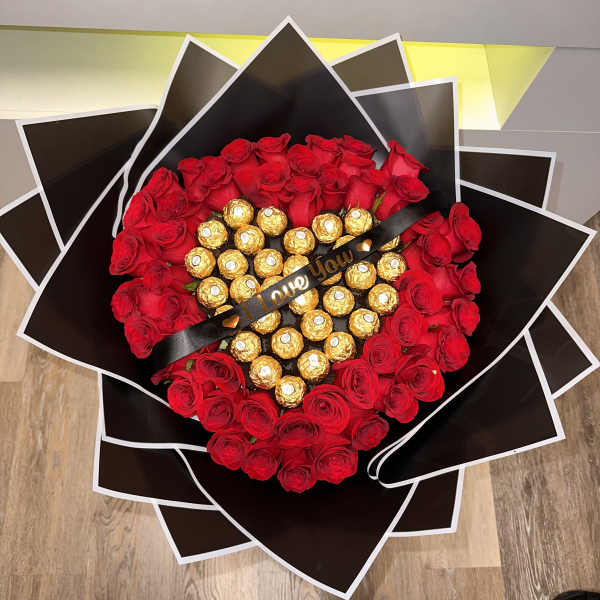Heart-shaped bouquet of red roses with gold-wrapped chocolates and a black ribbon