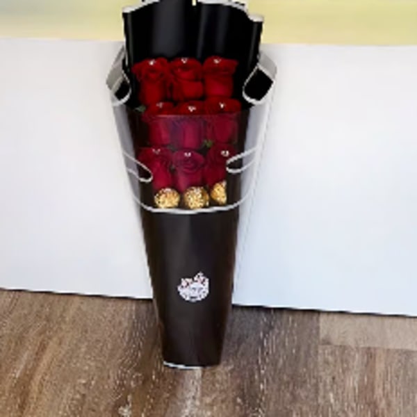 Bouquet of red roses wrapped in dark paper with gold accents