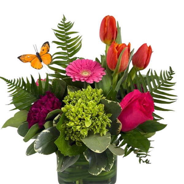 Mixed bouquet in a square glass vase with tulips, a gerbera daisy, and a rose