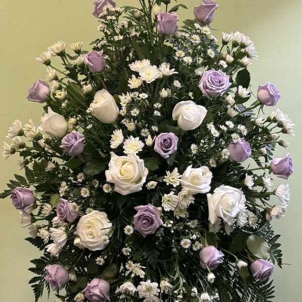 Standing floral spray with lavender and white roses and small white daisies