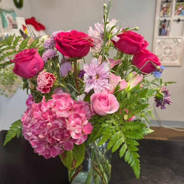 Pink roses and hydrangea arranged in a glass vase