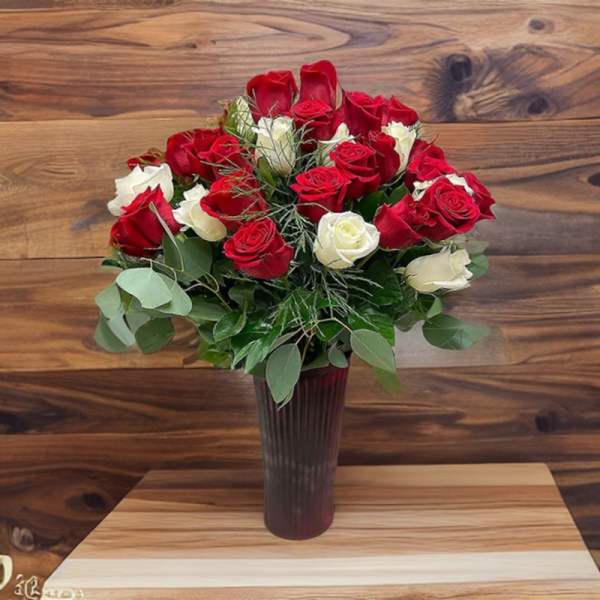 Bouquet of red and white roses in a tall dark vase