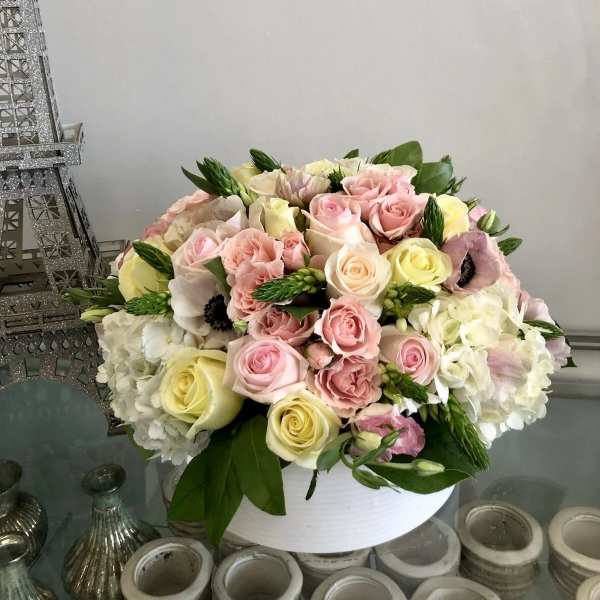 Bouquet of pink and cream roses with white hydrangeas in a white vase