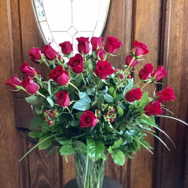 Red roses arranged in a clear glass vase