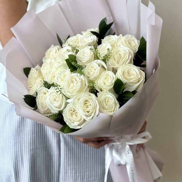 Bouquet of white roses wrapped in pale pink paper
