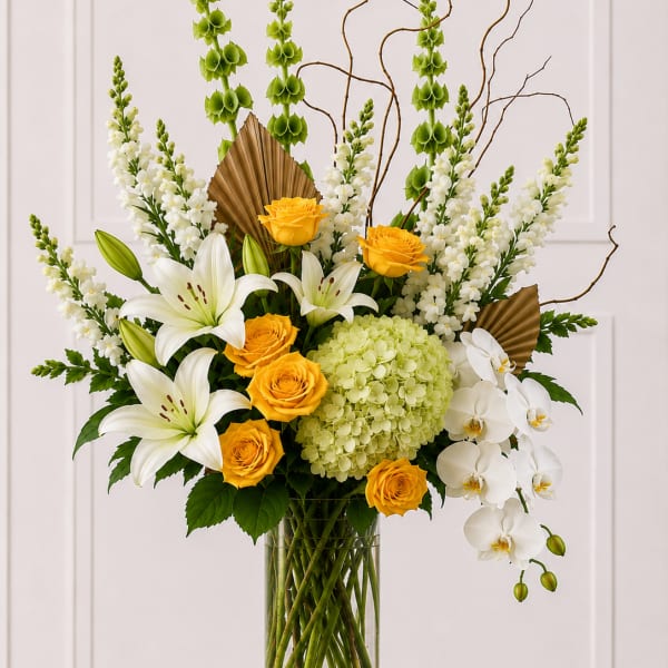 Tall bouquet of white lilies, yellow roses, and white orchids in a glass vase
