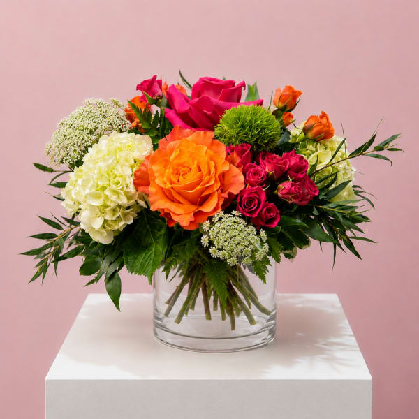 Bright mixed bouquet of roses and hydrangeas in a clear glass vase