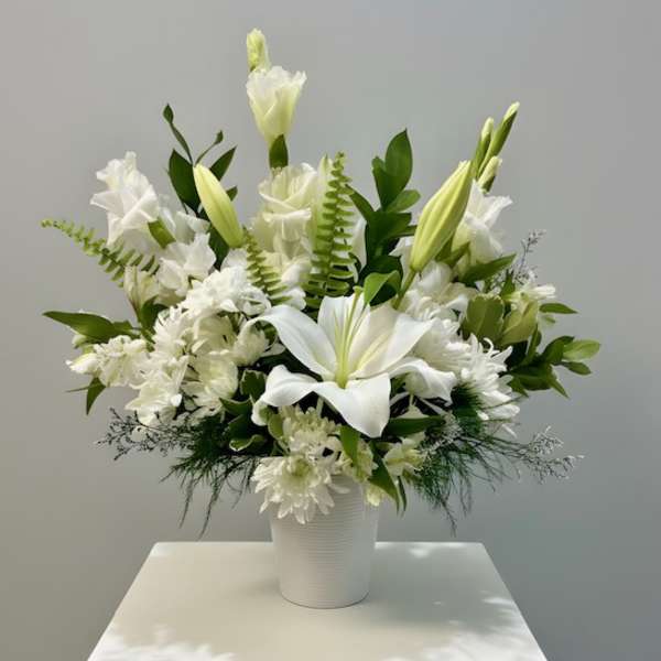 White lilies and chrysanthemums arranged in a white vase