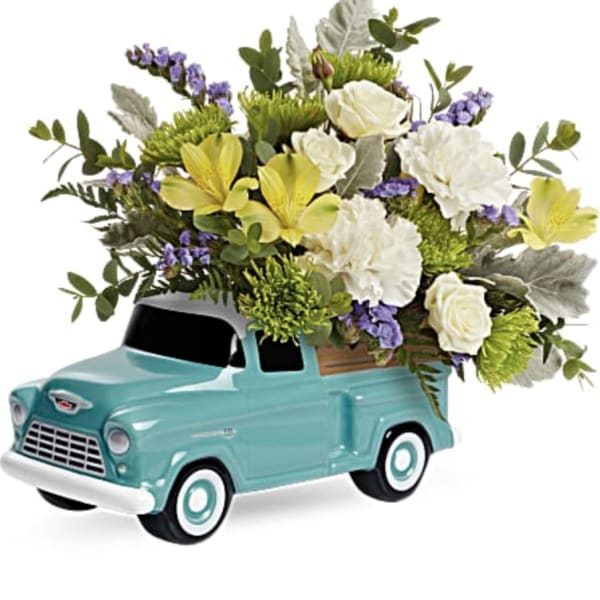 Bouquet of white and yellow flowers arranged in a turquoise toy truck