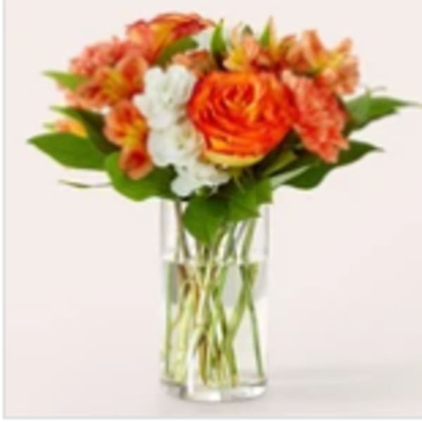 Orange and white bouquet in a clear glass vase