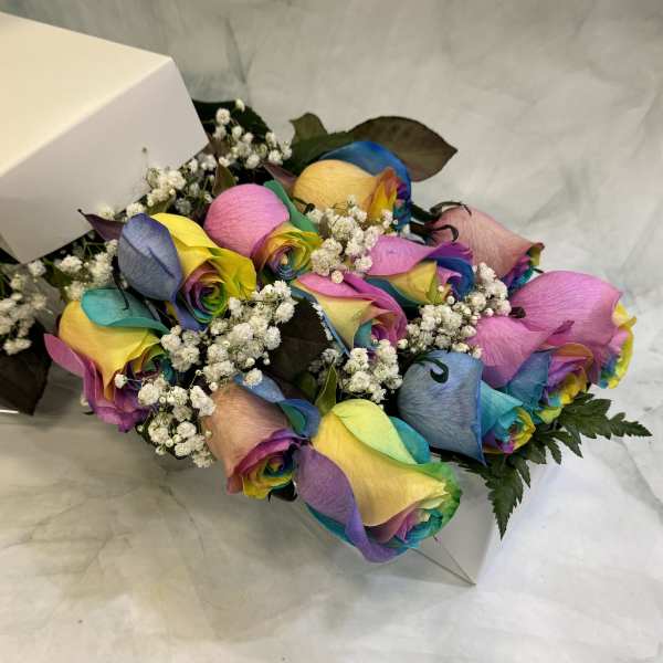 Bouquet of rainbow-colored roses with baby's breath in a white box