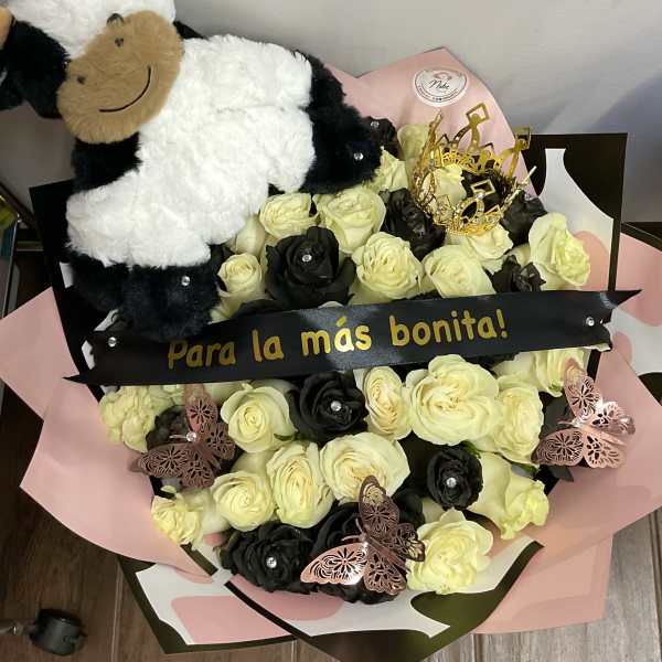 Bouquet of cream and black roses with a plush cow and decorative butterflies