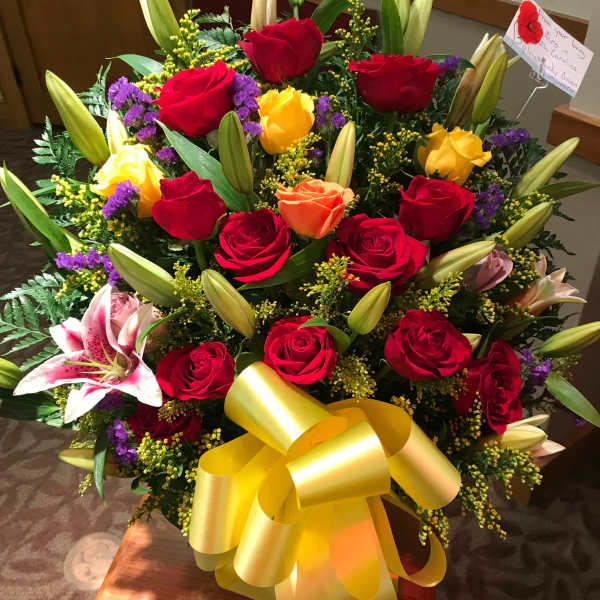 Large bouquet of red and yellow roses with lilies and a yellow bow