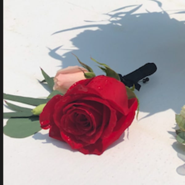 Red rose boutonniere with pale pink accent flowers