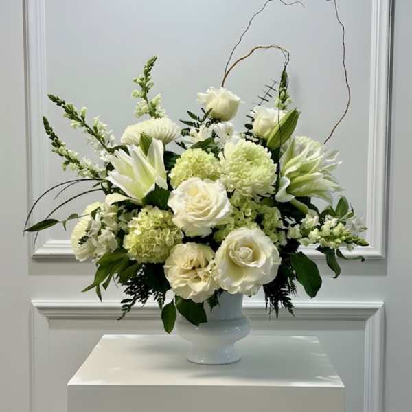 White floral arrangement in a white pedestal vase