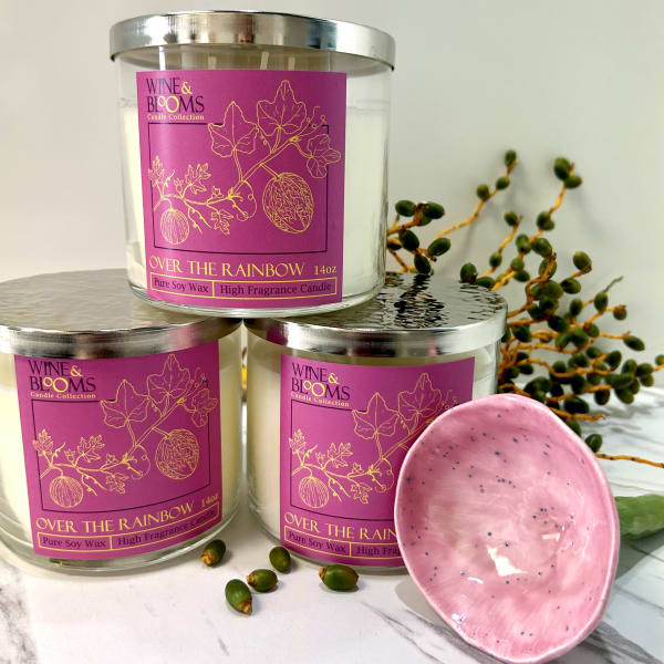 Three labeled candles with a pink dish and decorative berries