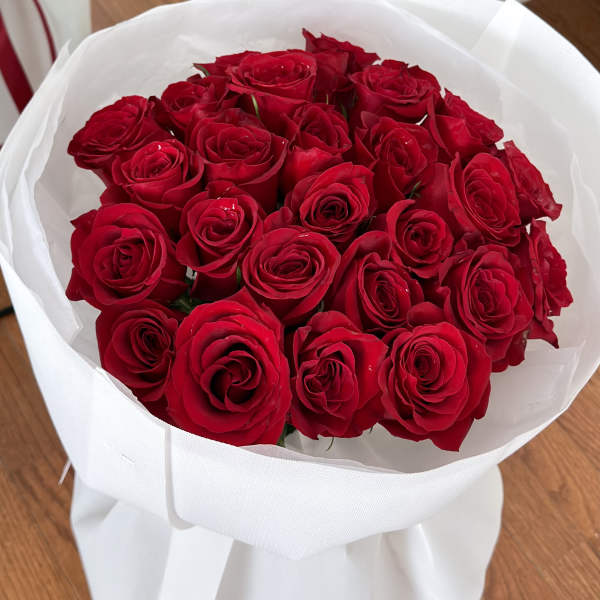 Bouquet of red roses wrapped in white paper