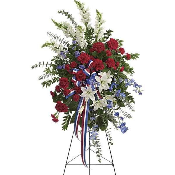 Standing floral spray with red, white, and blue flowers on an easel