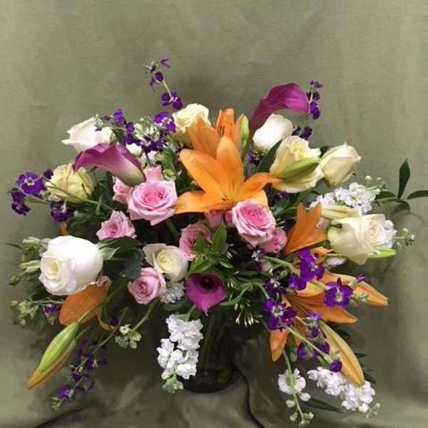 Mixed bouquet with orange lilies, pink roses, white roses, and purple calla lilies
