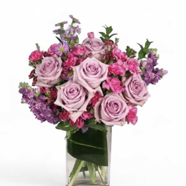 Lavender and pink rose bouquet in a clear glass vase