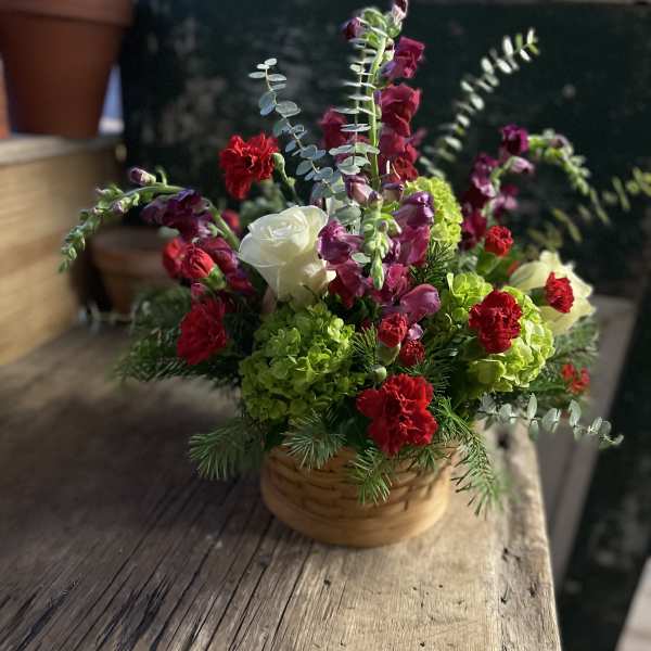 Basket arrangement with red and white flowers and green blooms