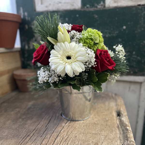 Bouquet of red roses, white gerbera daisy, and green hydrangea in a metal bucket