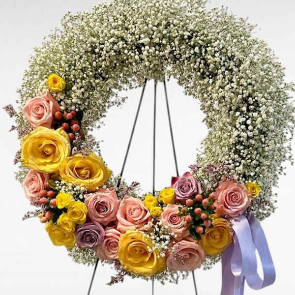 Floral wreath with pastel roses and baby's breath on a stand