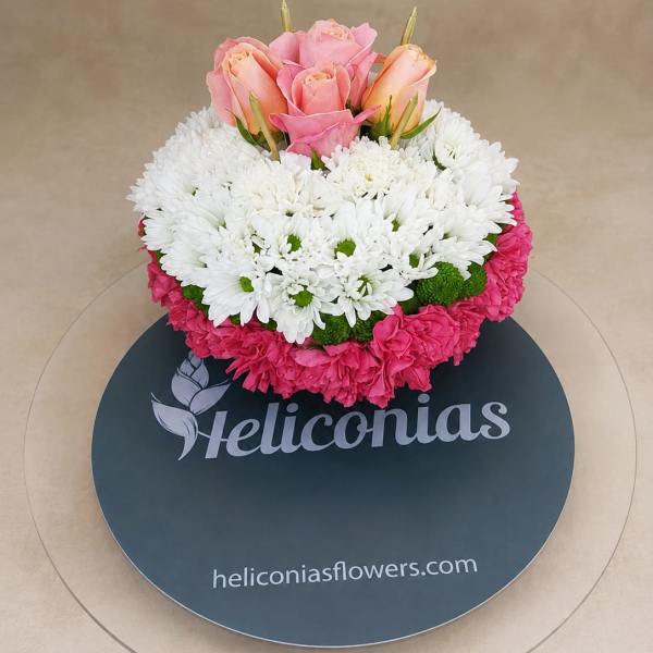 Pink roses and white daisies in a round floral arrangement