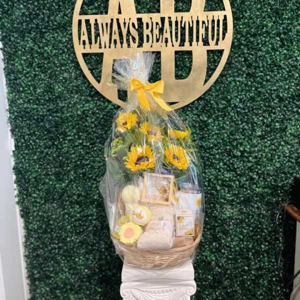 Gift basket with sunflowers and assorted items wrapped in clear cellophane