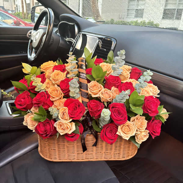 Basket of red and peach roses with eucalyptus in a car seat