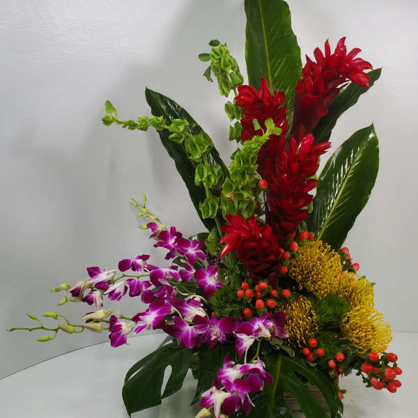 Tropical arrangement with red ginger, purple orchids, and yellow pincushion blooms