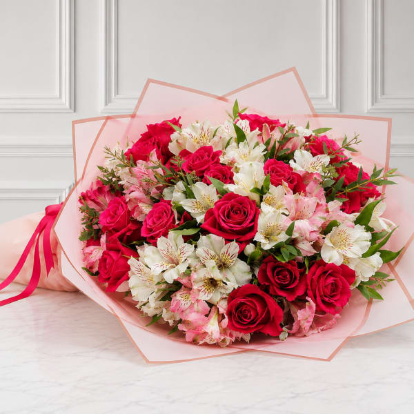 Bouquet of red roses and white-pink alstroemeria wrapped in pink paper
