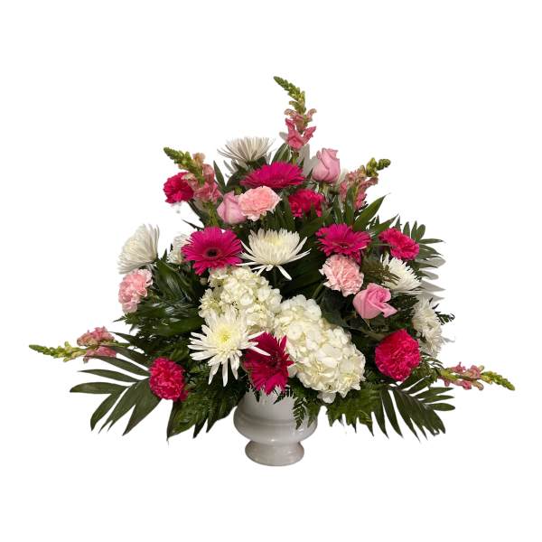 Pink and white mixed flower arrangement in a white urn vase