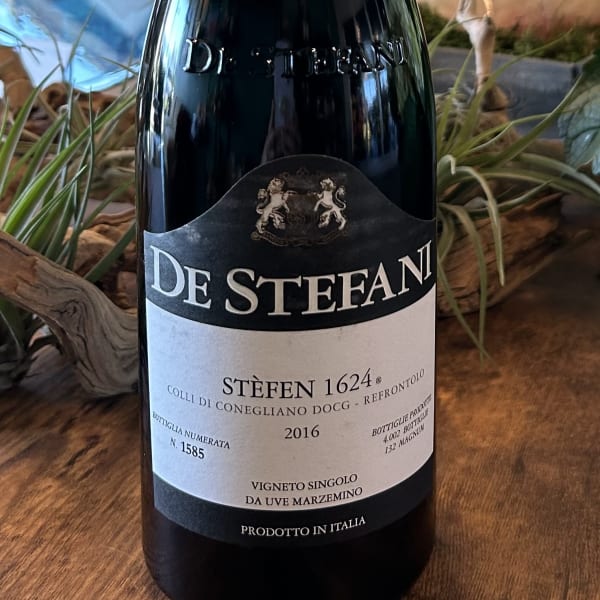 A bottle of De Stefani wine on a wooden surface