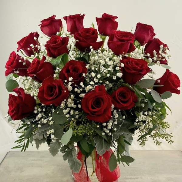Bouquet of red roses with baby's breath in a glass vase