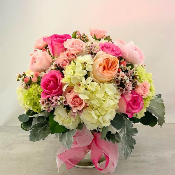 Pink and peach rose bouquet with pale hydrangeas in a glass vase