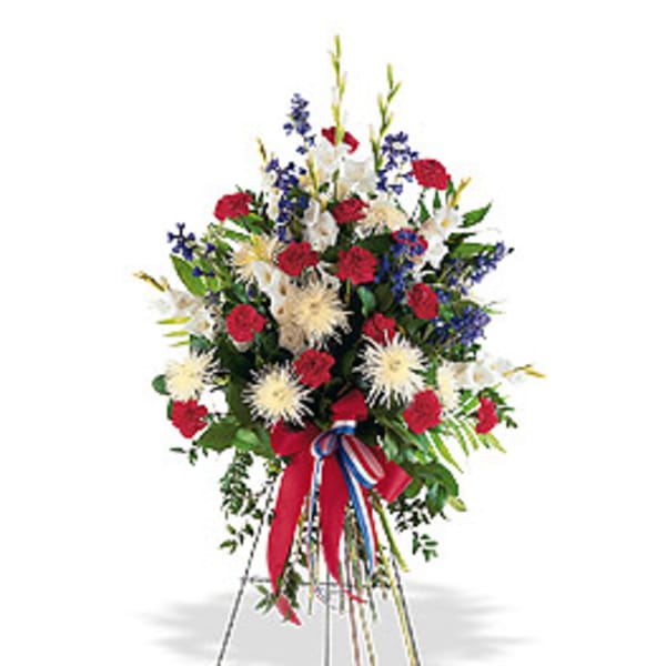 Tall red, white, and blue standing spray with carnations, mums, and ribbon on an easel