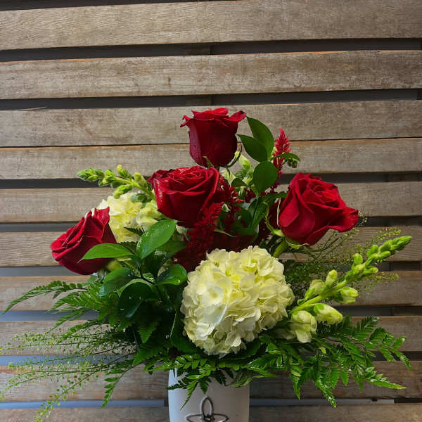 Red roses and white hydrangeas in a white vase