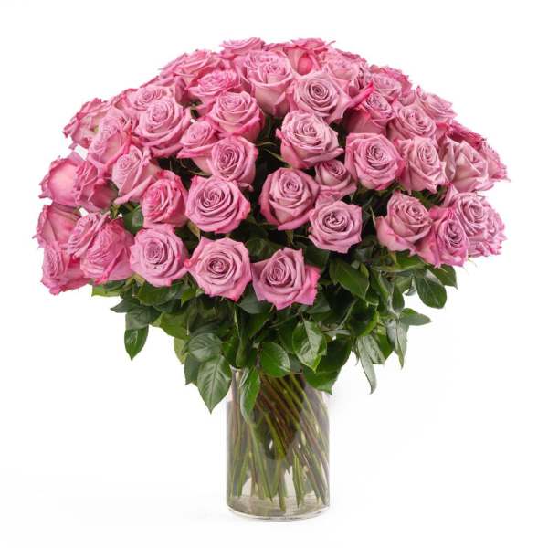 Large bouquet of pink roses arranged tightly in a clear glass vase
