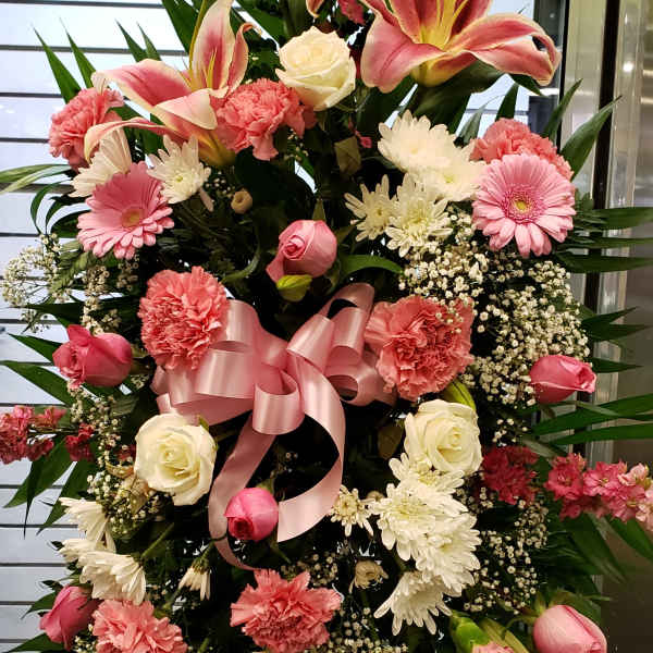 Standing floral spray with pink lilies, roses, and carnations