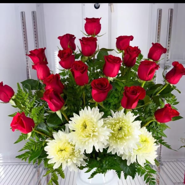 Red roses and white chrysanthemums arranged in a white vase