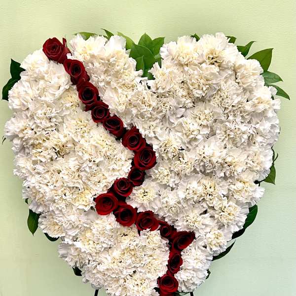 Heart-shaped white carnation arrangement with a diagonal line of red roses