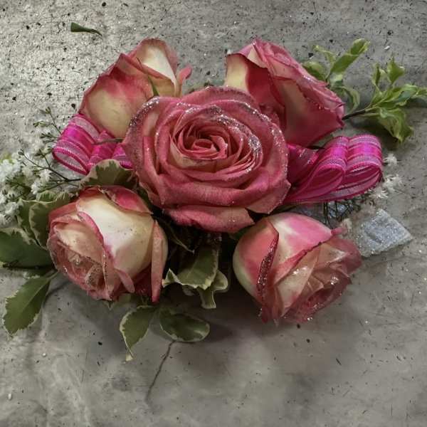 Pink roses with ribbon accents and variegated greenery