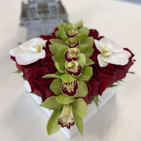 Heart-shaped bouquet of red roses with green and white orchids