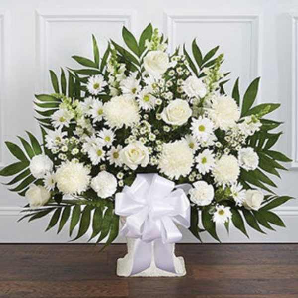 White floral standing spray with a large white bow on a stand