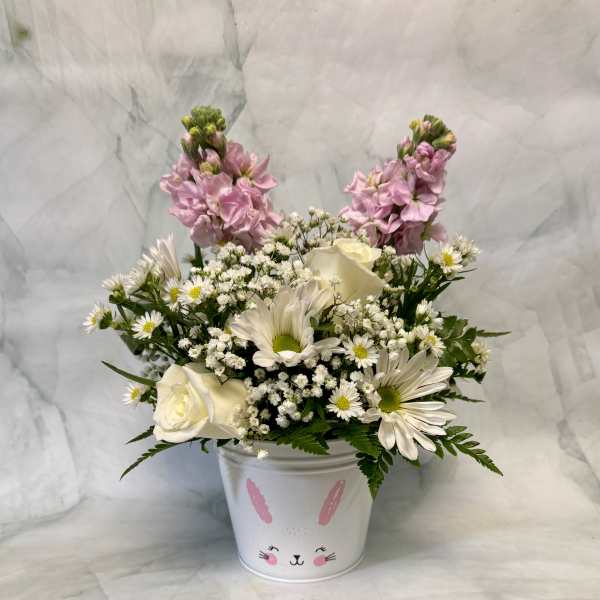 Pink and white flowers arranged in a bunny-decorated bucket