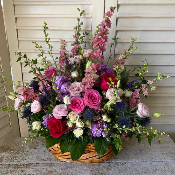 Basket arrangement of pink, purple, white, and red flowers