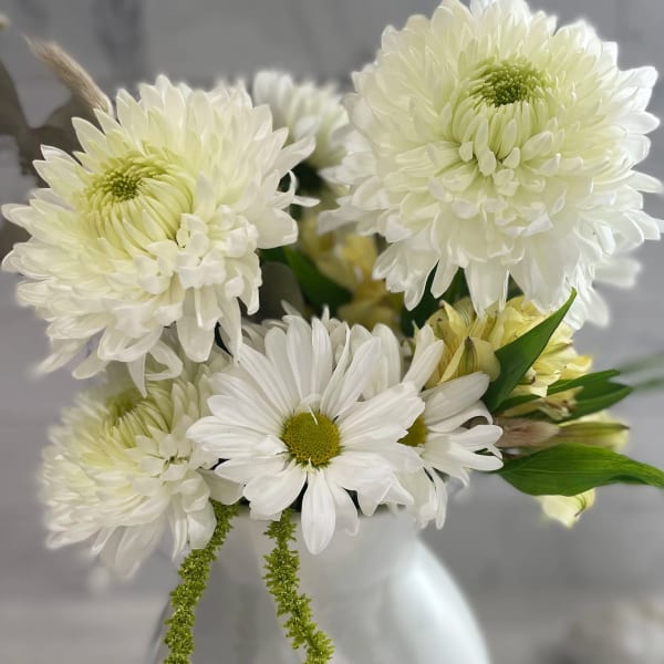 White daisy and chrysanthemum bouquet in a white vase