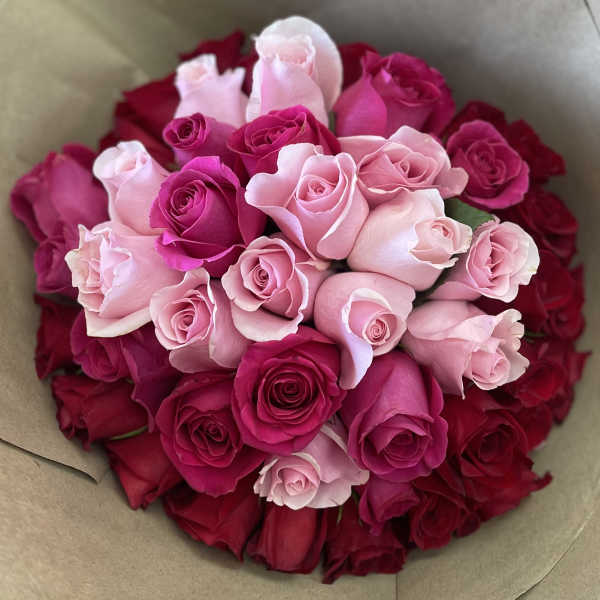 Bouquet of pink and red roses wrapped in brown paper